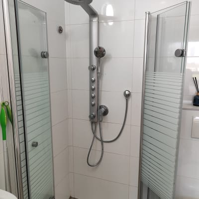 מקלחת עם ראש גשם ודלתות זכוכית