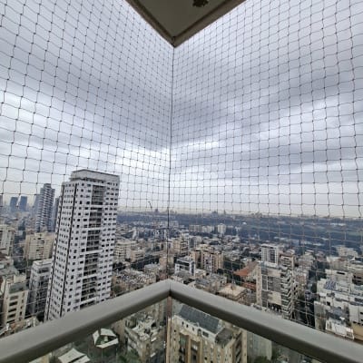 רשת יונים מותקנת במרפסת עם נוף עירוני