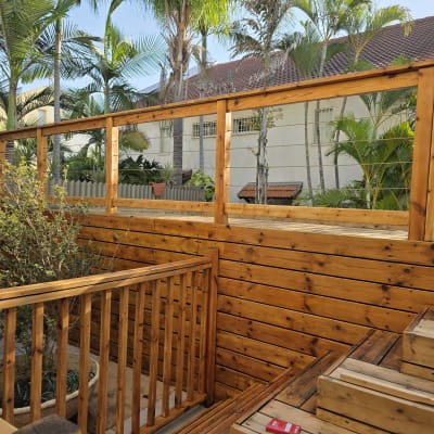 גדר עץ בגינה עם צמחים ועצים ברקע