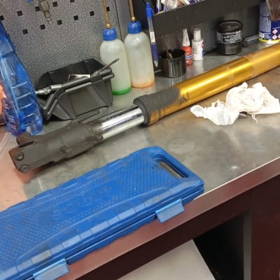 כלי עבודה וחלקי אופנוע על שולחן עבודה במוסך