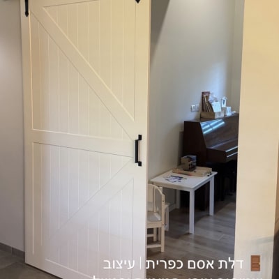 דלת הזזה לבנה עם מסילה שחורה בחדר