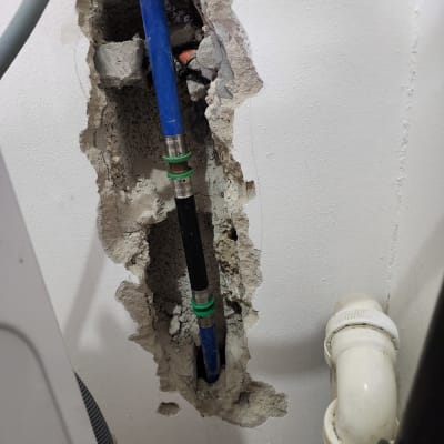 צינור מים כחול בקיר עם חיבורי מתכת