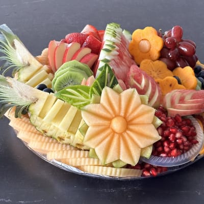 מגש פירות מעוצב עם פרחים ופירות שונים