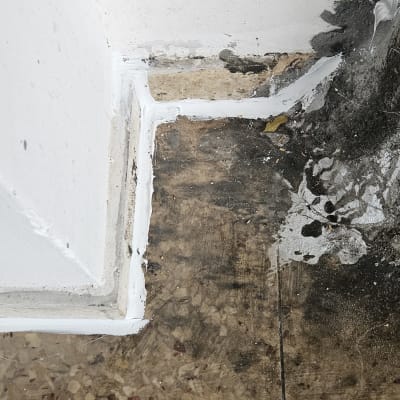 איטום פינה עם חומר לבן על רצפה וקיר