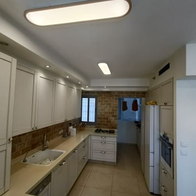 מטבח משופץ עם ארונות חדשים ותאורה מודרנית