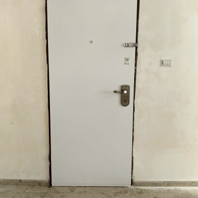 דלת לבנה עם ידית ומנעול כסופים