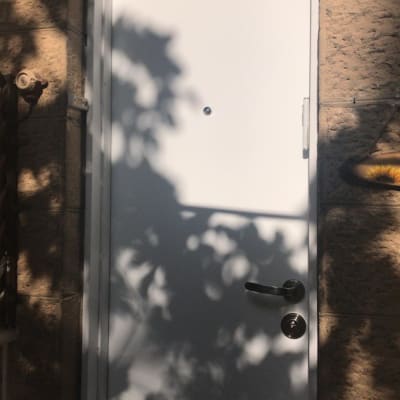 דלת לבנה עם ידית מתכת וצללים