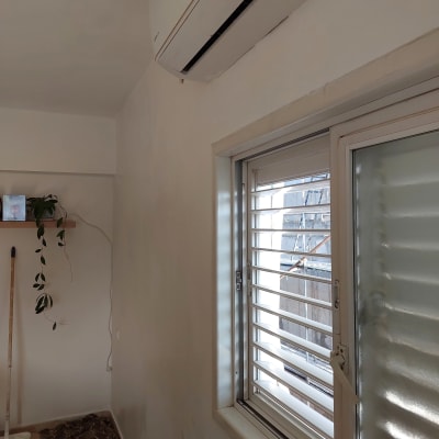 מגש צבע ומברשת על הרצפה ליד קיר צבוע