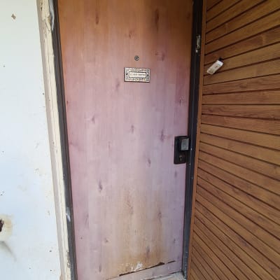 דלת עץ עם סימני שחיקה וידית שחורה