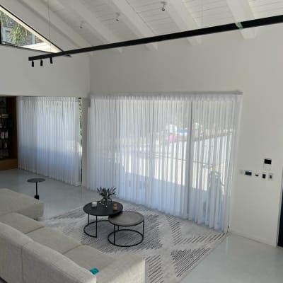 וילונות לבנים שקופים תלויים על חלונות גדולים