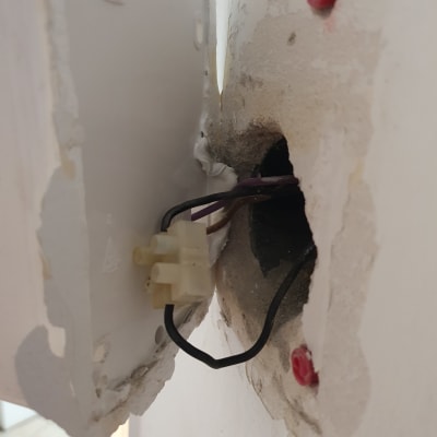 חוטי חשמל יוצאים מקופסת חיבורים בקיר