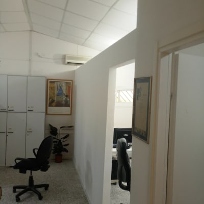 קיר גבס לבן במשרד עם כיסאות ומחשבים