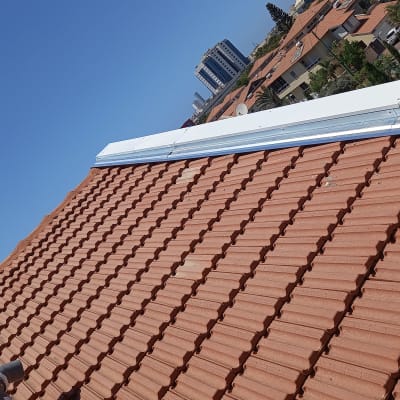 גג רעפים חומים עם פס מתכת לבן