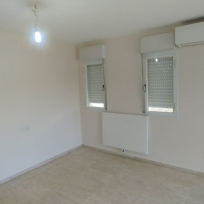 קיר צבוע בלבן עם חלונות ותריסים