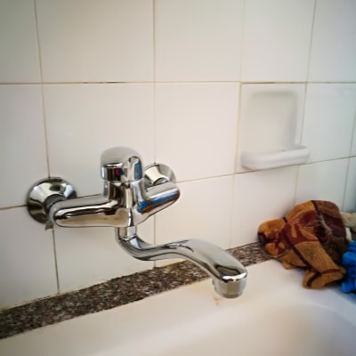 ברז כרום מותקן על קיר אריחים לבנים