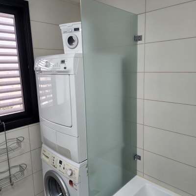 מחיצת זכוכית ליד אמבטיה בחדר רחצה