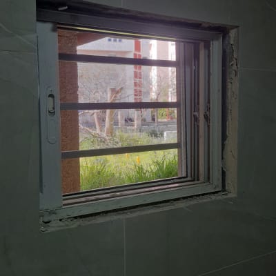 חלון אלומיניום עם סורגים ומסגרת אפורה