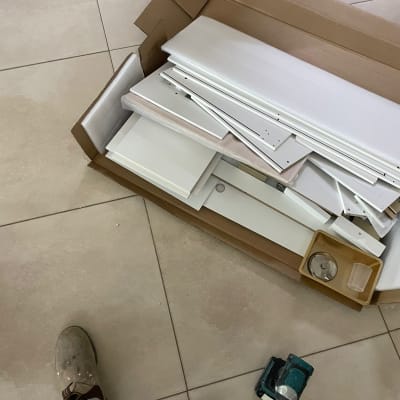 חלקי רהיטים בקופסה, מקדחה על הרצפה