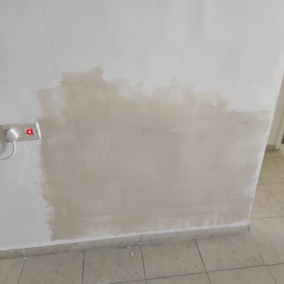 קיר עם תיקון טיח ליד שקע חשמל