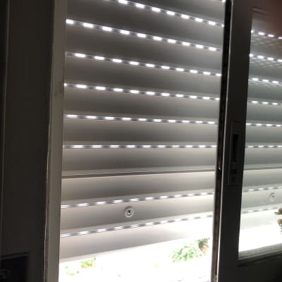 תריסים לבנים פתוחים למחצה עם אור חודר