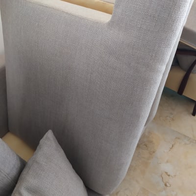 ספה אפורה עם כריות על רצפת שיש