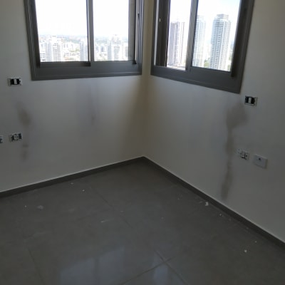 חדר עם קירות צבועים חלקית וכתמי צבע