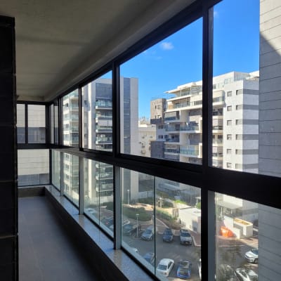 חלונות אלומיניום גדולים במרפסת בניין