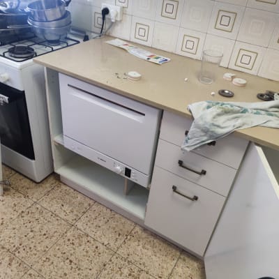 מדיח כלים מותקן במטבח עם כלים על השיש