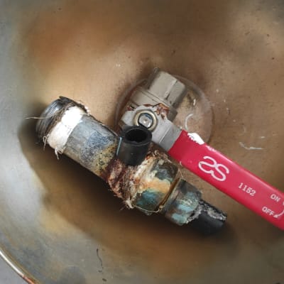 שסתום מתכת חלוד עם ידית אדומה