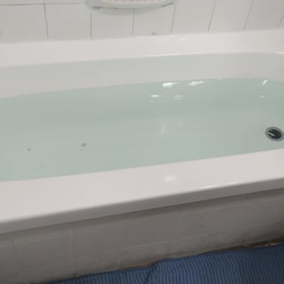 אמבטיה מלאה במים עם אריחים לבנים