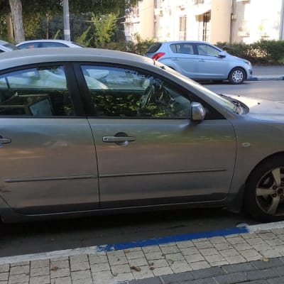 מכונית חונה בצד הדרך עם סימני נזק בצד