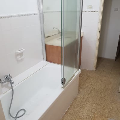 אמבטיה עם דלת זכוכית ומקלחת יד