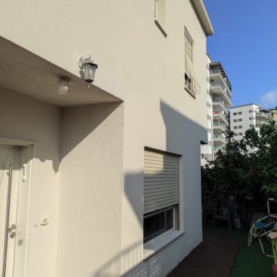 קיר חיצוני עם חלון ותריס סגור, מנורה על הקיר