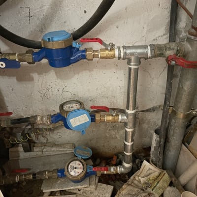 מד מים כחול עם צינורות וברזים אדומים