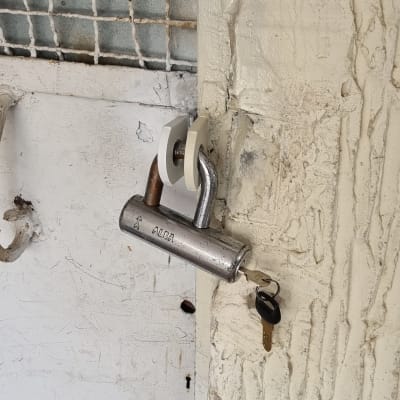 מנעול תלוי על דלת עם מפתח בפנים