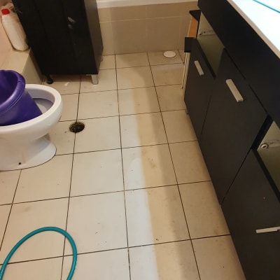 רצפה מלוכלכת עם דלי סגול וצינור כחול