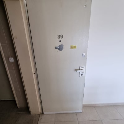 דלת מתכת עם מספר 39 וידית לבנה