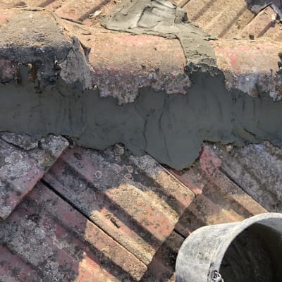 תיקון גג רעפים עם מלט טרי ודלי