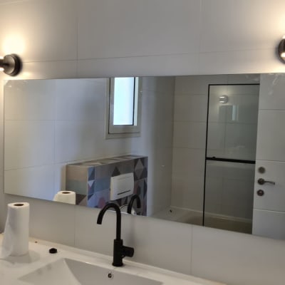 מנורות קיר מעל מראה בחדר אמבטיה