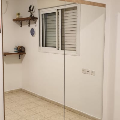 מראה גדולה עם מסגרת עץ על קיר לבן