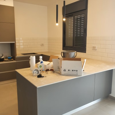 מטבח בשיפוץ עם קופסאות וכלי עבודה על השיש