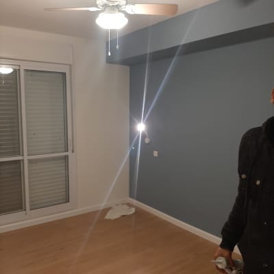 חדר עם קיר צבוע, מאוורר תקרה ורצפת עץ