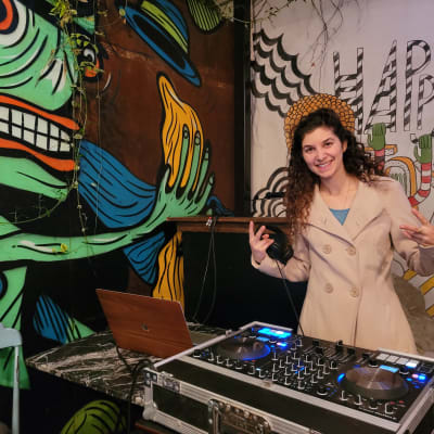 אישה עם ציוד DJ, שולחן מיקסר ומחשב נייד