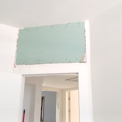 לוח גבס ירוק מותקן מעל דלת לבנה