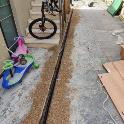 צינור שחור מונח בתעלה עם חצץ