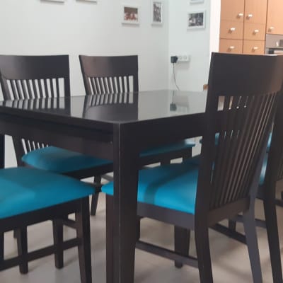 כיסאות עם ריפוד כחול סביב שולחן עץ כהה