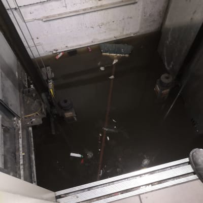 בור מעלית מוצף במים עם מטאטא צף