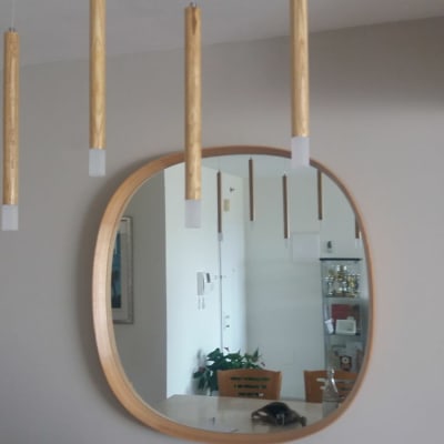 מראה עגולה עם מסגרת עץ על קיר אפור