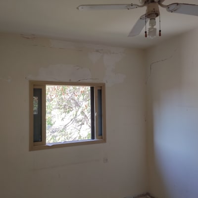 קירות עם סדקים ותיקוני צבע בחדר