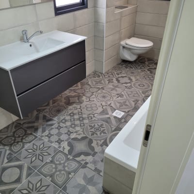 חדר אמבטיה נקי עם כיור, אסלה ורצפה מעוצבת